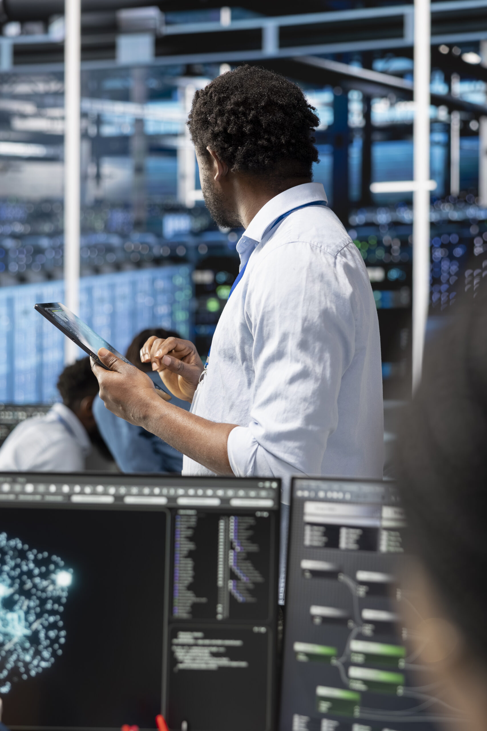 Photo of an engineer holding a tablet in the control room of a data centre 