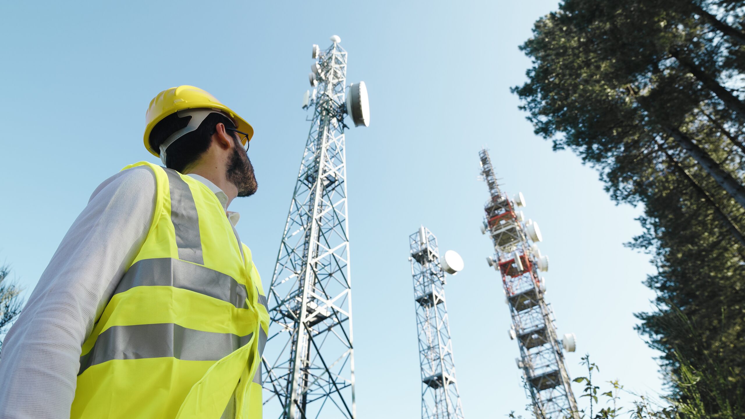 Photo of a technician standing in front of masts with radio equipment