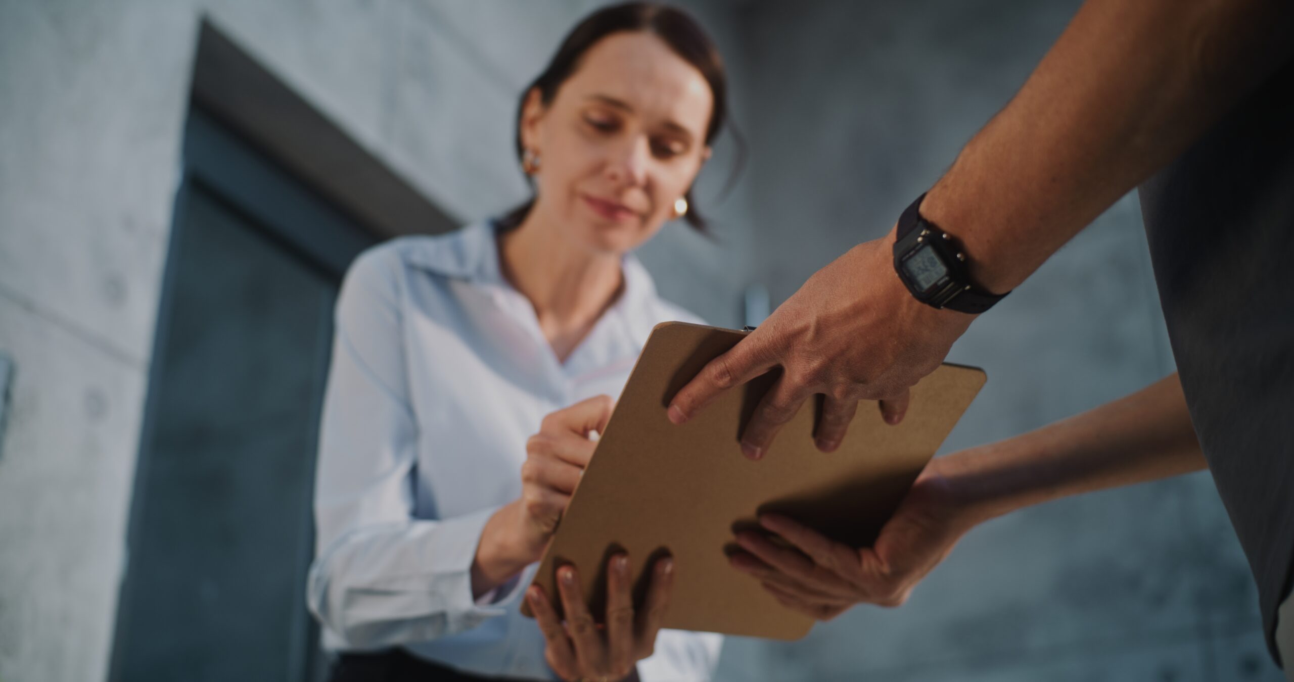 Photo of a woman in her thirties signing for a parcel or letter on a tablet